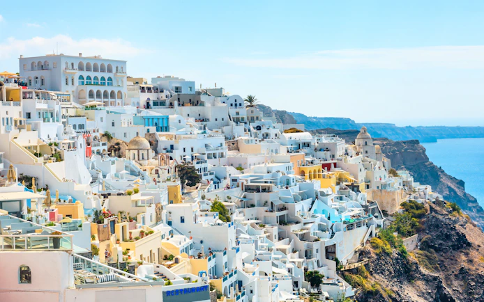 Fira old town in Santorini with whitewashed buildings on a cliff overlooking the Aegean Sea.