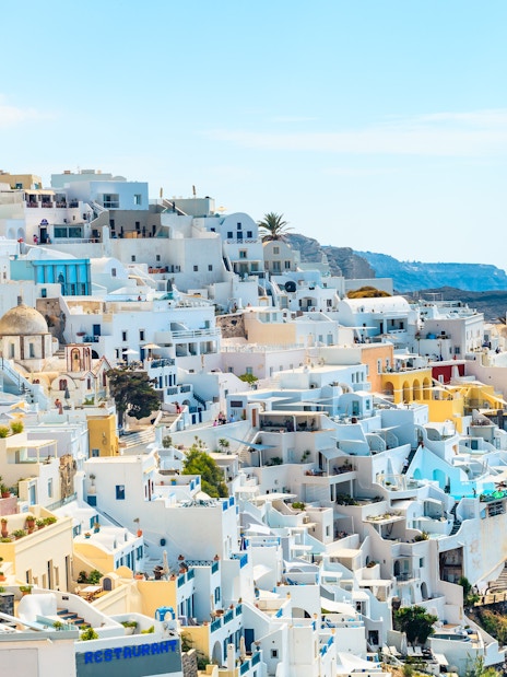 Fira old town in Santorini with whitewashed buildings on a cliff overlooking the Aegean Sea.