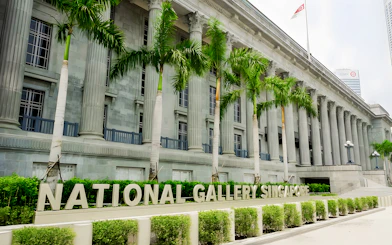 National Gallery Singapore exterior with columns and palm trees.