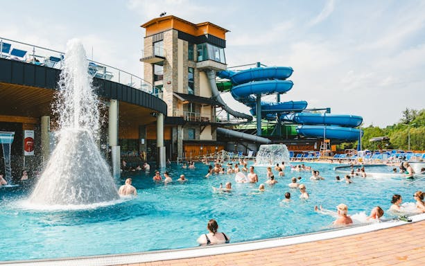 Outdoor pool with people enjoying water slides at a Zakopane resort during a day trip from Krakow.