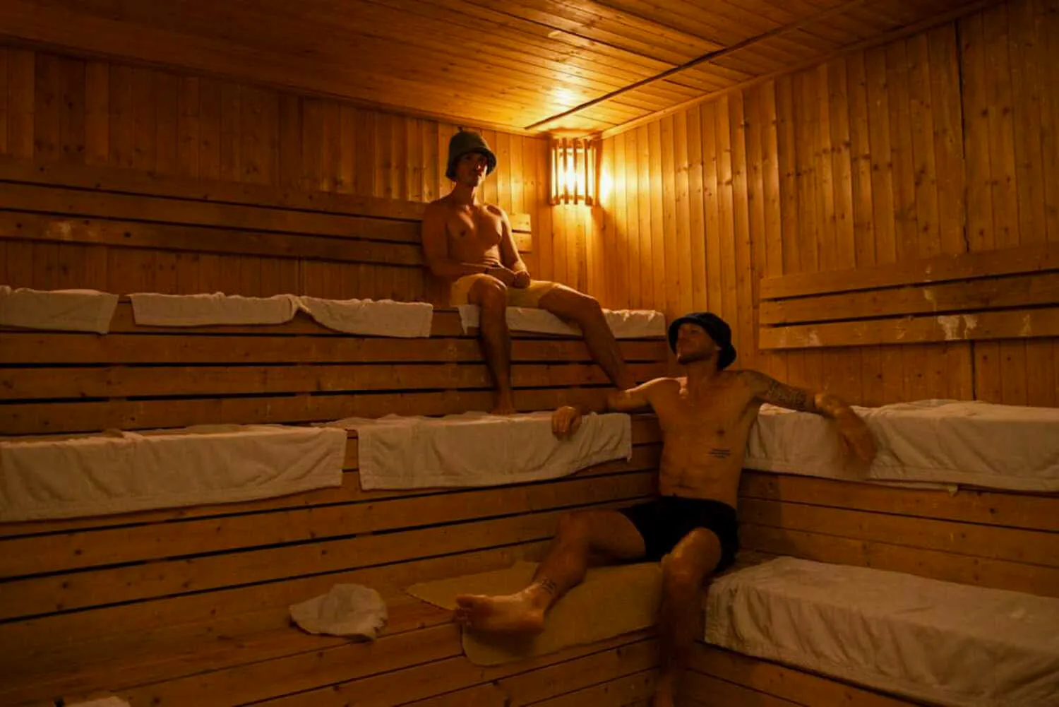 Two people relaxing in a wooden sauna at Yunomori Onsen & Spa, Pattaya.