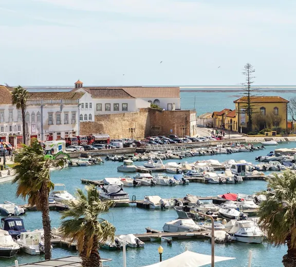Faro marina view with boats and historic buildings along the waterfront.