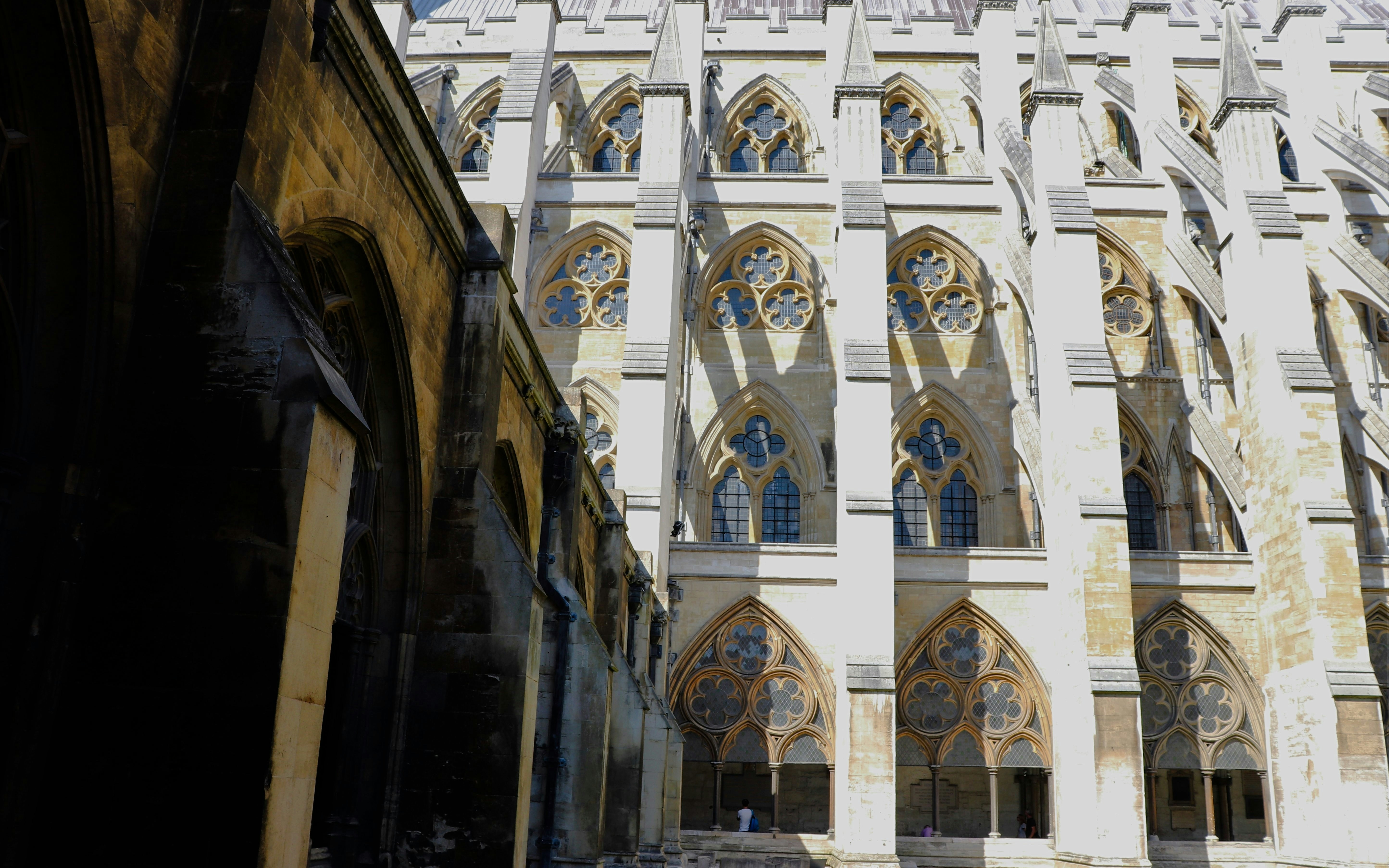 Westminster Abbey cloisters with detailed Gothic arches and stone columns.