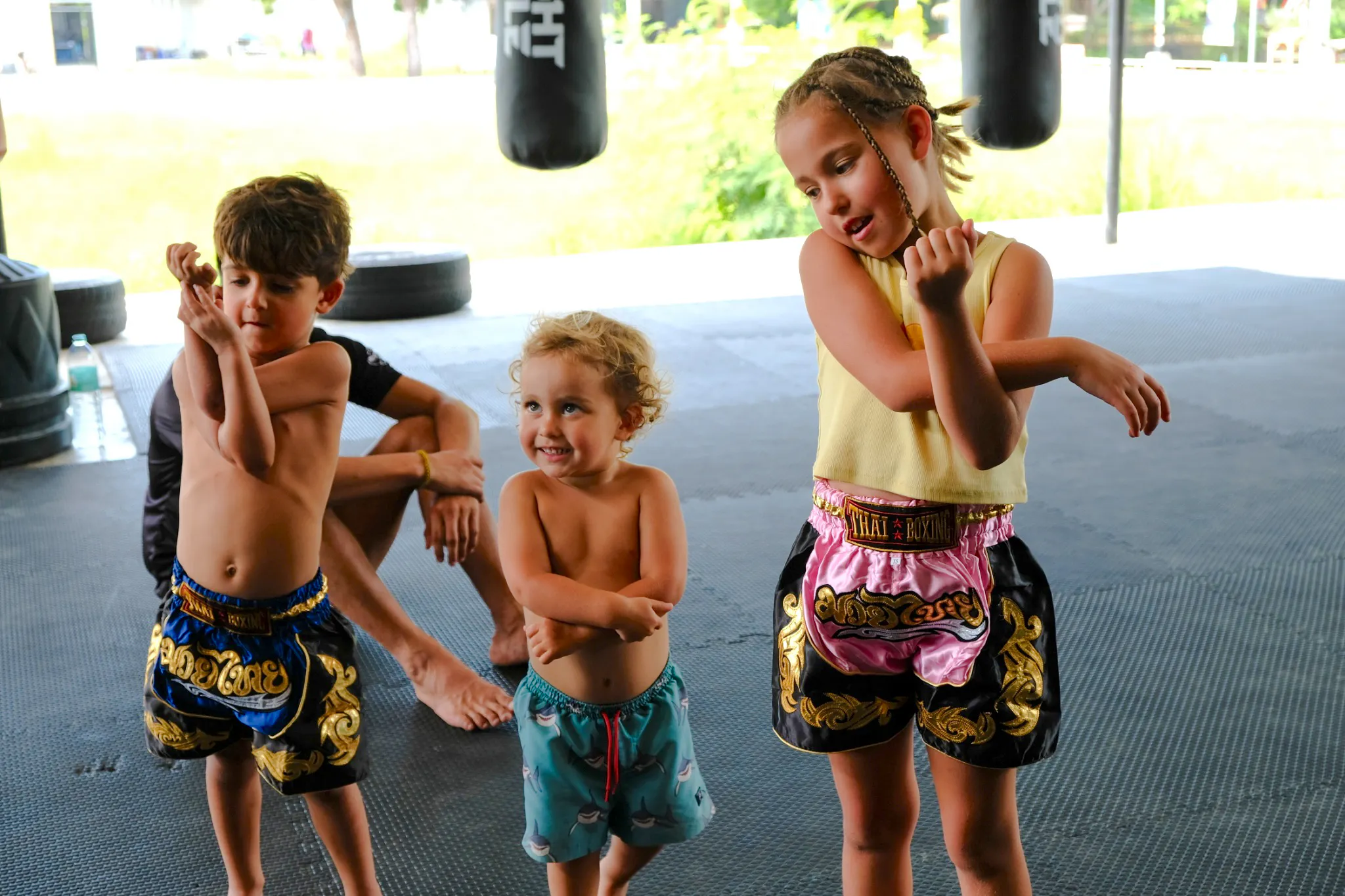 Children practicing Muay Thai moves in a Krabi boxing class.