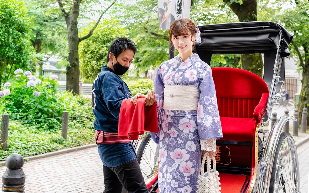 Rickshaw ride in Japan with woman in kimono and guide assisting.