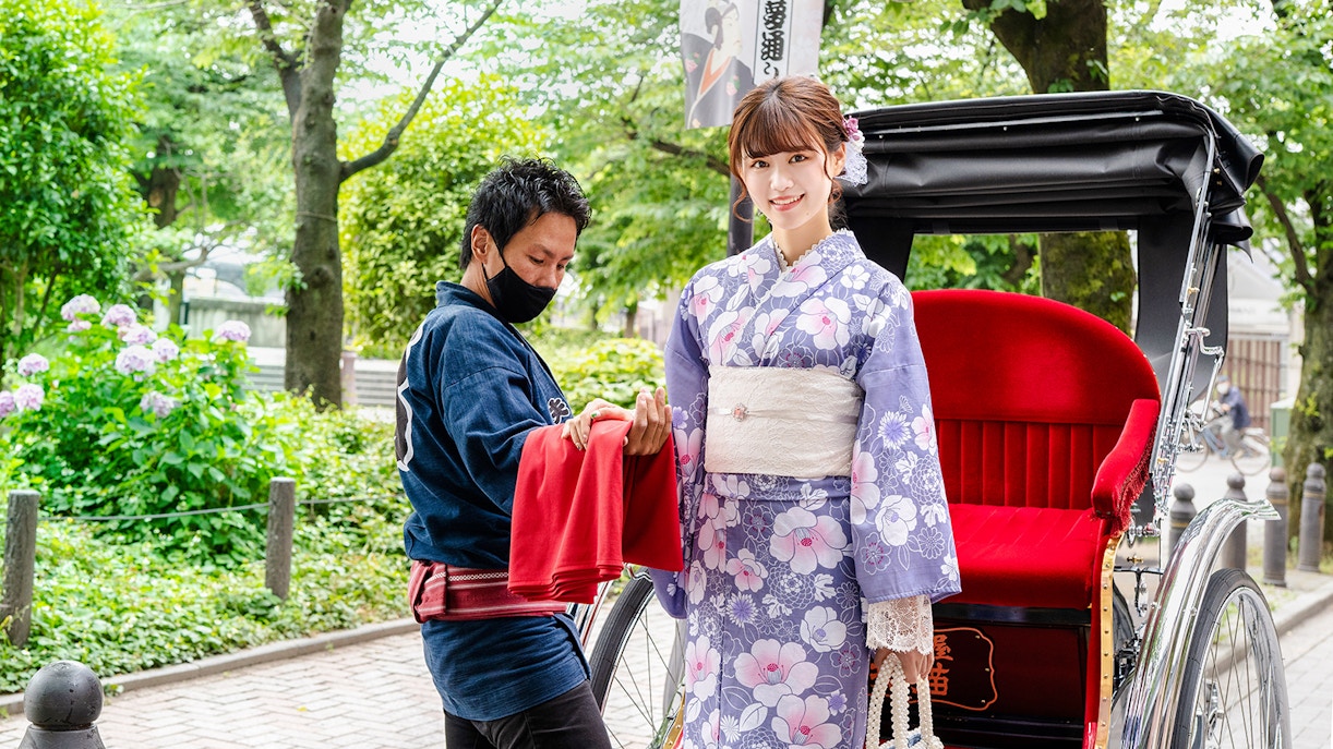 Rickshaw ride in Japan with woman in kimono and guide assisting.