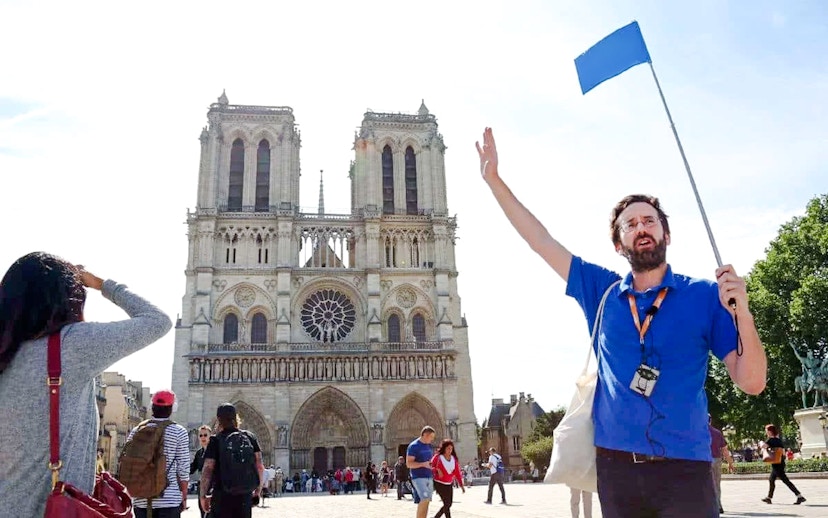 Guide leading a tour in front of Notre Dame Cathedral, Paris, France.