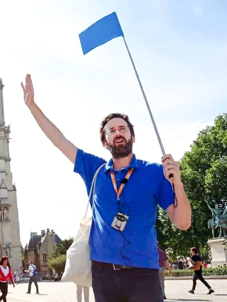 Guide leading a tour in front of Notre Dame Cathedral, Paris, France.