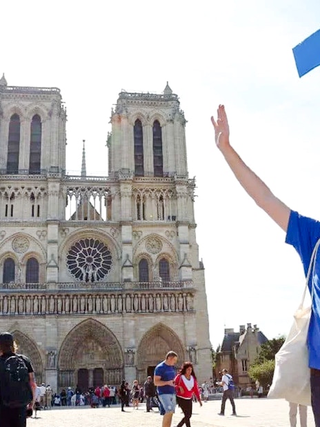 Guide leading a tour in front of Notre Dame Cathedral, Paris, France.