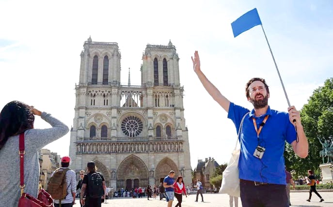Guide leading a tour in front of Notre Dame Cathedral, Paris, France.