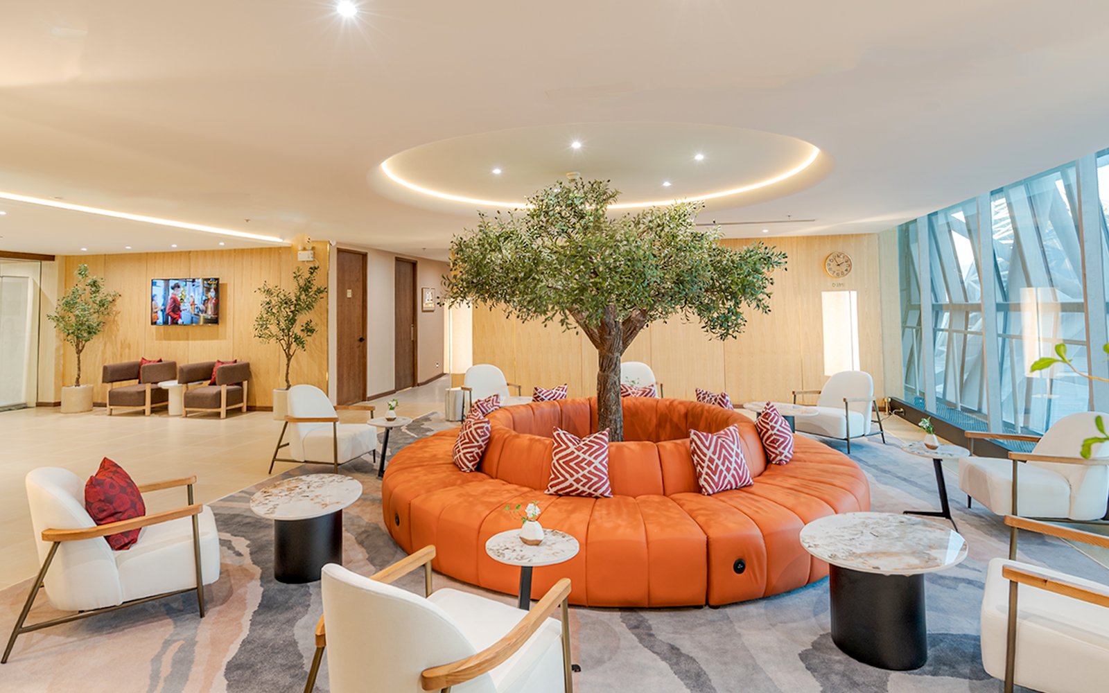 Coral Airport Lounge seating area with tree centerpiece at Suvarnabhumi Airport.