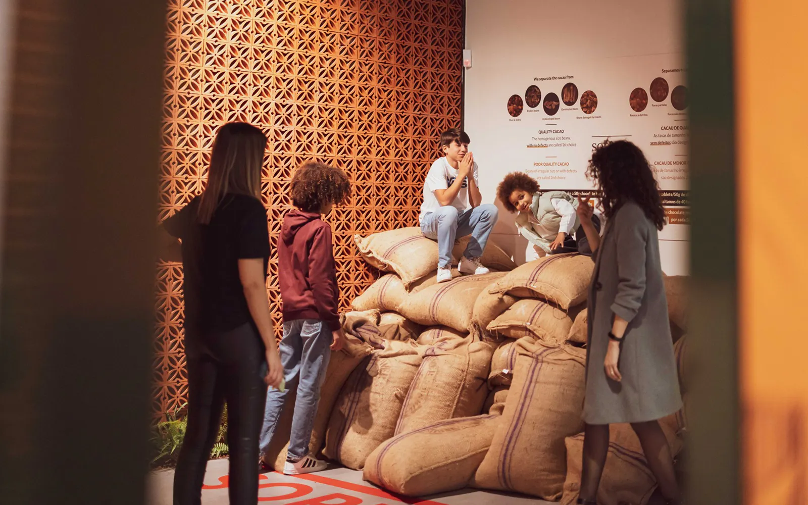 Visitors exploring cocoa bean sacks at Taylor's Port Cellars in Porto.
