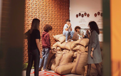 Visitors exploring cocoa bean sacks at Taylor's Port Cellars in Porto.