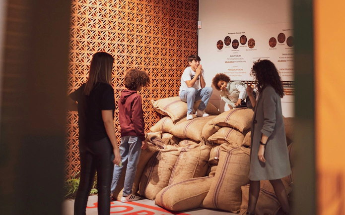 Visitors exploring cocoa bean sacks at Taylor's Port Cellars in Porto.