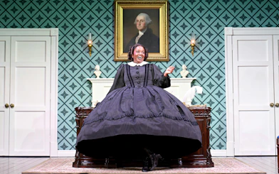 Performer in period costume on stage in "Oh Mary" at West End theater.