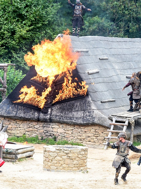 Viking reenactment with actors and burning roof at Puy du Fou, France.