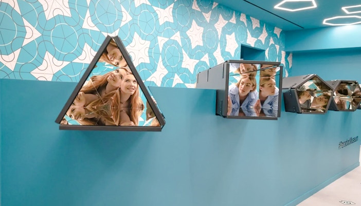 Visitors interacting with mirrored installations in the Kaleidoscope room at Paradox Museum Paris.