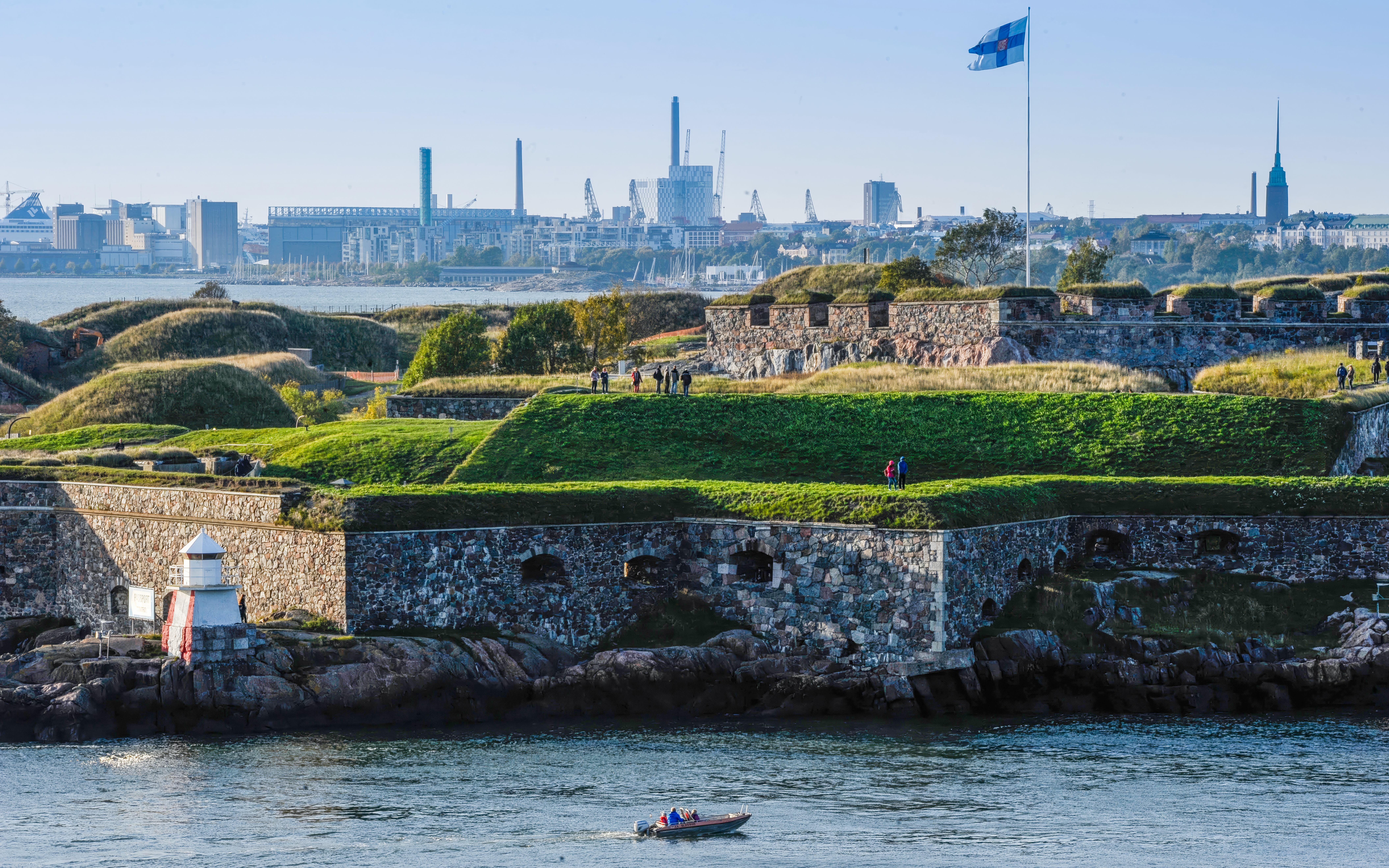 Suomenlinna Sea Fortress with visitors and Finnish flag, Helsinki, Finland.