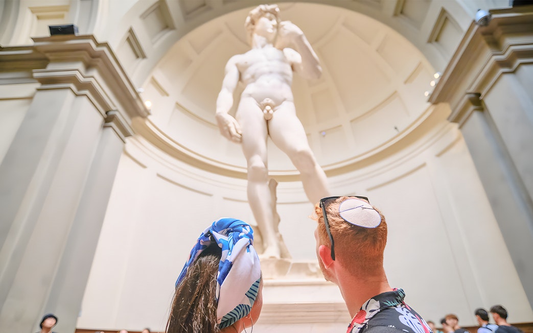 Couple admiring Michelangelo's David at Accademia Gallery, Florence.