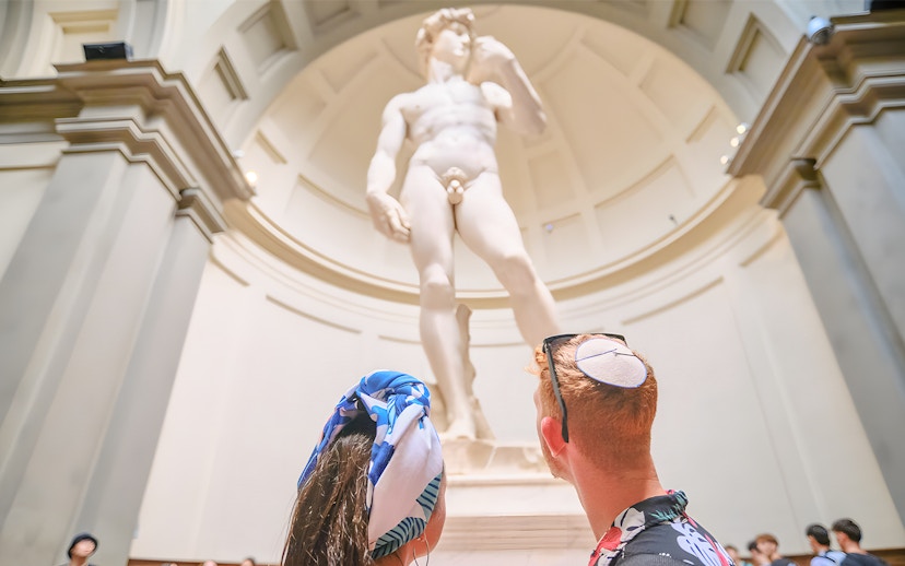 Couple admiring Michelangelo's David at Accademia Gallery, Florence.