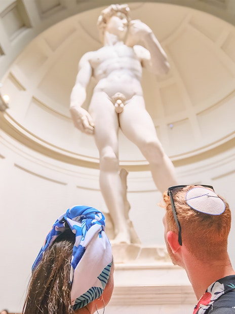 Couple admiring Michelangelo's David at Accademia Gallery, Florence.