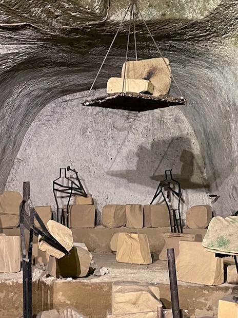 Naples Underground ruins with ancient stone structures and metal frames.