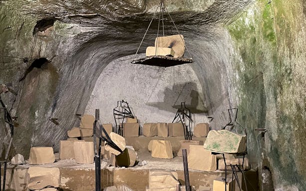 Naples Underground ruins with ancient stone structures and metal frames.