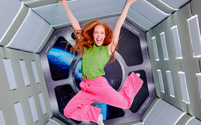Guest jumping in space-themed room at Paradox Museum London.