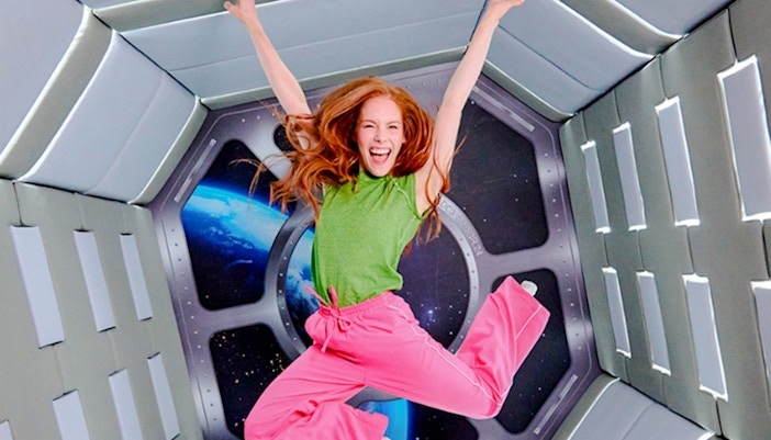 Guest jumping in space-themed room at Paradox Museum London.