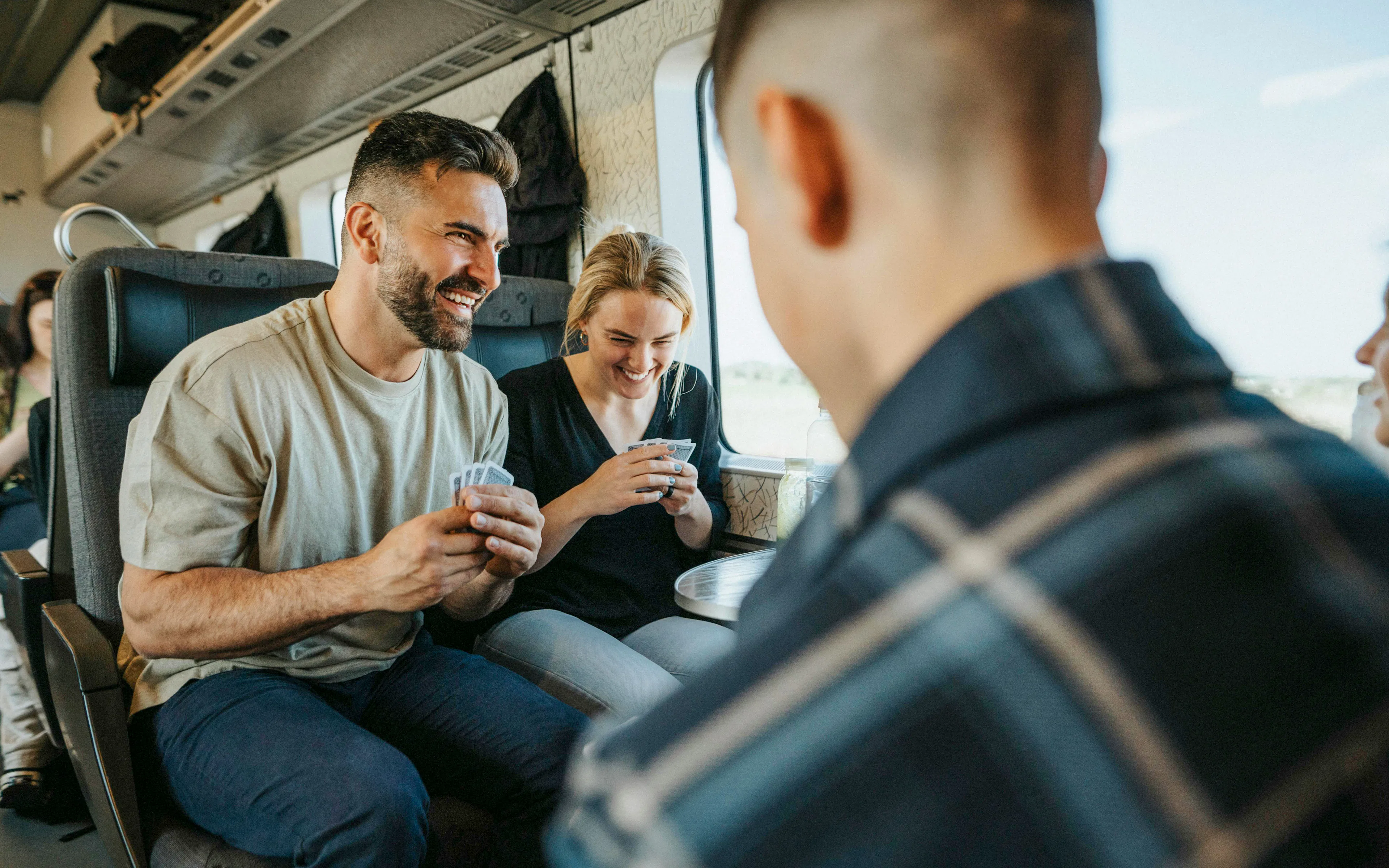 Passengers playing cards on a train in London.