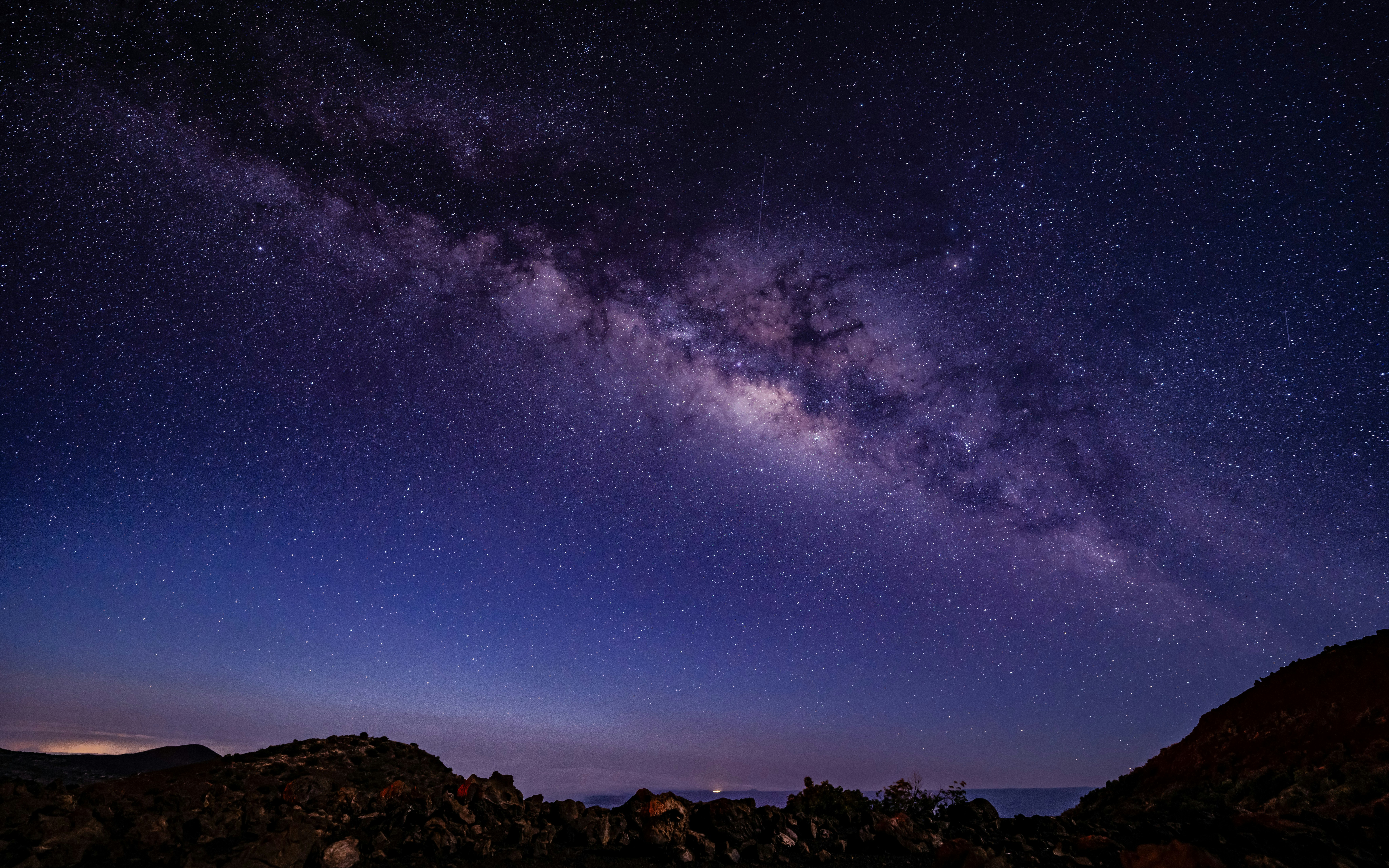 Stargazing at Mauna Kea observatory under a clear night sky with the Milky Way visible.