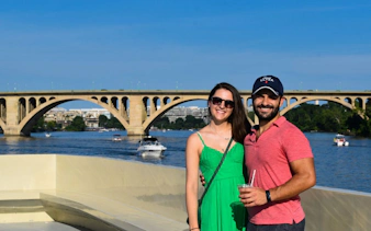 Couple on Potomac River cruise with view of Key Bridge in Washington, DC.