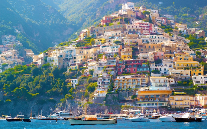 Colorful hillside buildings in Positano, Italy, viewed from the sea, part of the Amalfi Coast tour from Rome.