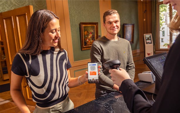 Visitors using I amsterdam City Card at museum entrance.
