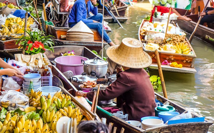 Boats with vendors selling fruits and goods at Damnern Saduak Floating Market, Thailand.