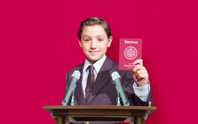 Child holding KidZania Singapore passport at podium with microphones.