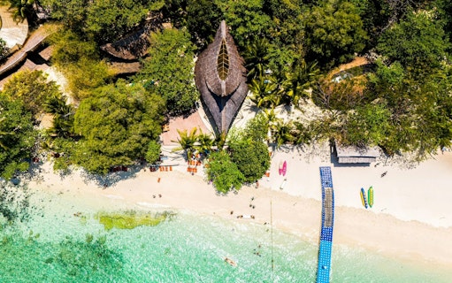 Aerial view of Banana Beach Koh Hey with clear water and lush greenery.
