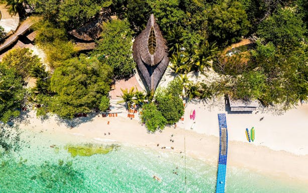 Aerial view of Banana Beach Koh Hey with clear water and lush greenery.