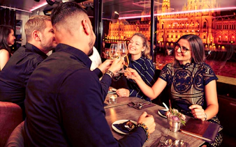 Guests toasting with drinks on Budapest Danube River Dinner & Lights Cruise.