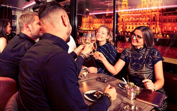 Guests toasting with drinks on Budapest Danube River Dinner & Lights Cruise.