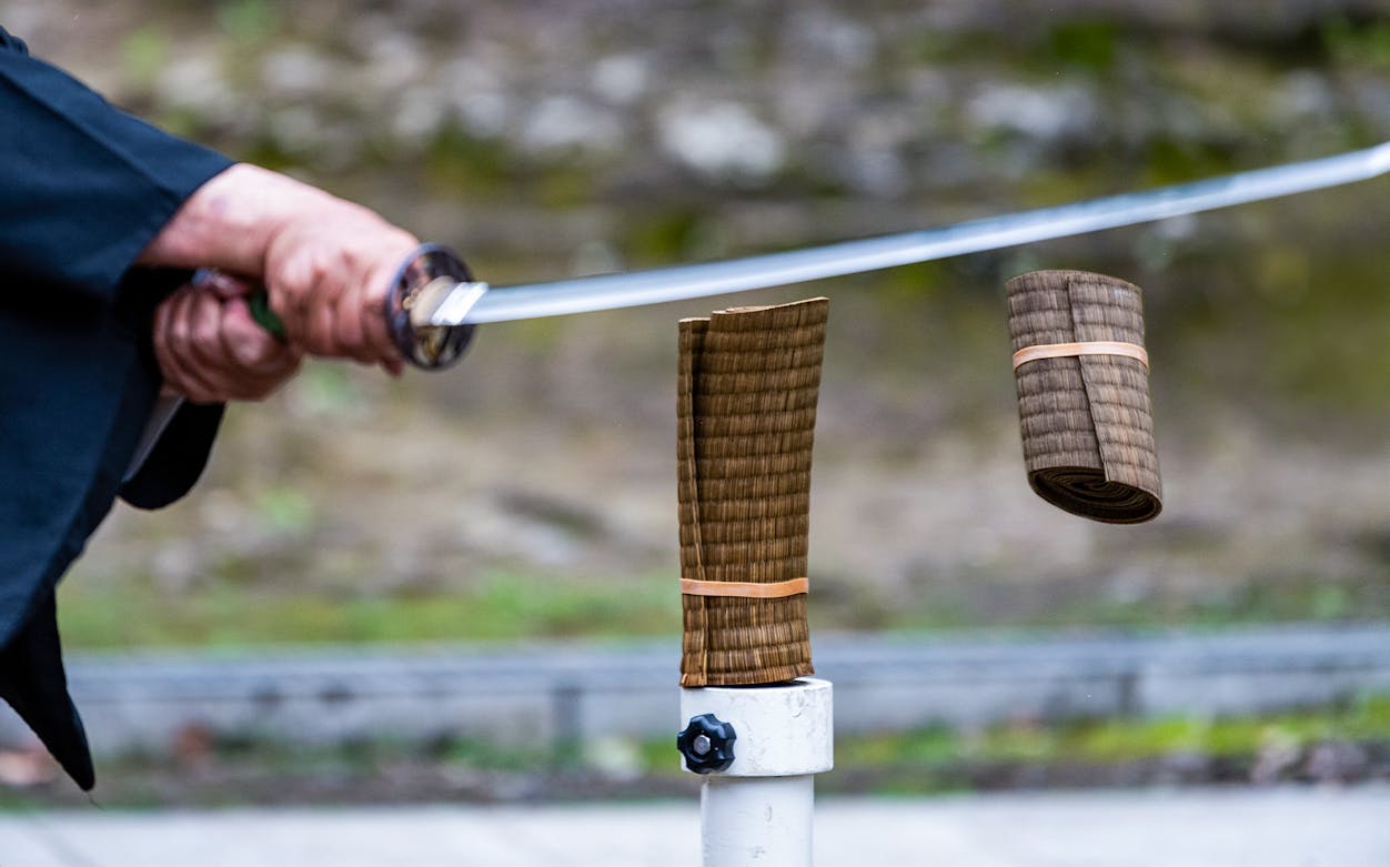 Samurai sword cutting through tatami mat during performance show.
