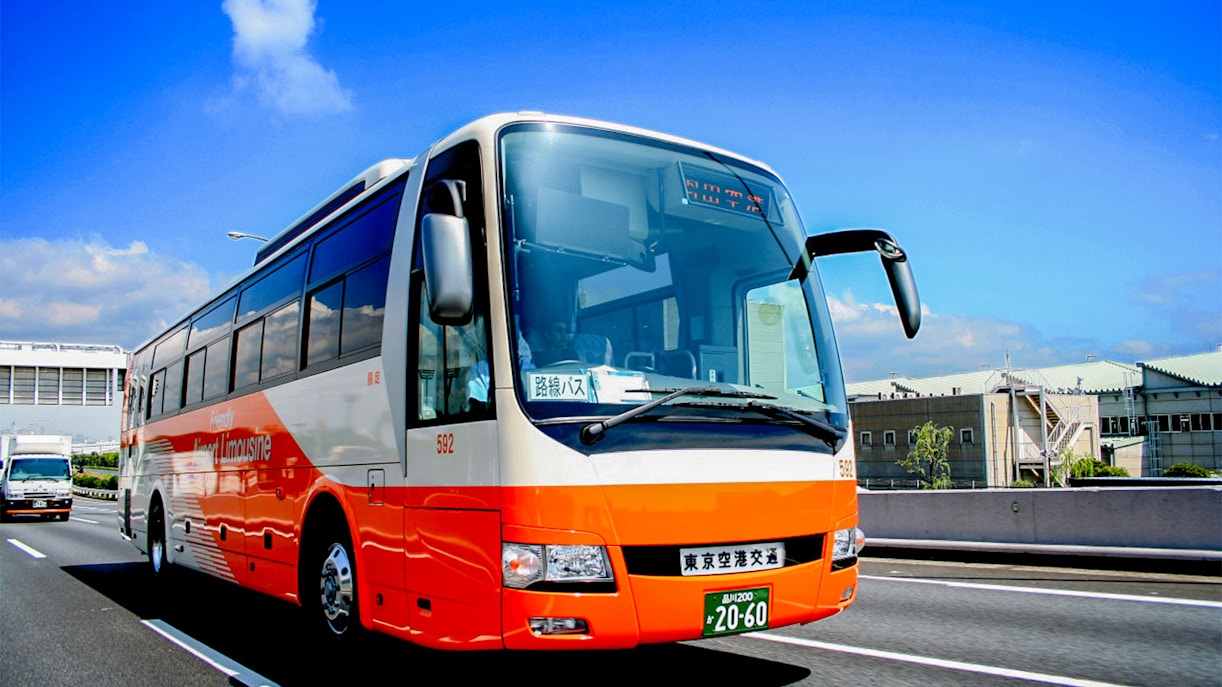 Tokyo Airport Limousine Bus driving on highway under clear sky.