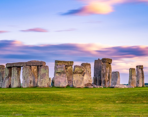 Stonehenge stone circle at sunset in England with colorful sky.