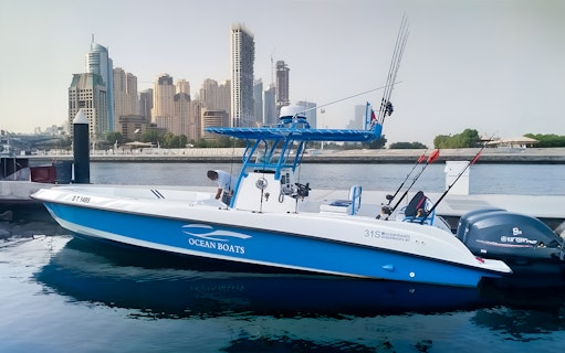 Private fishing charter boat docked with Dubai skyline in the background.