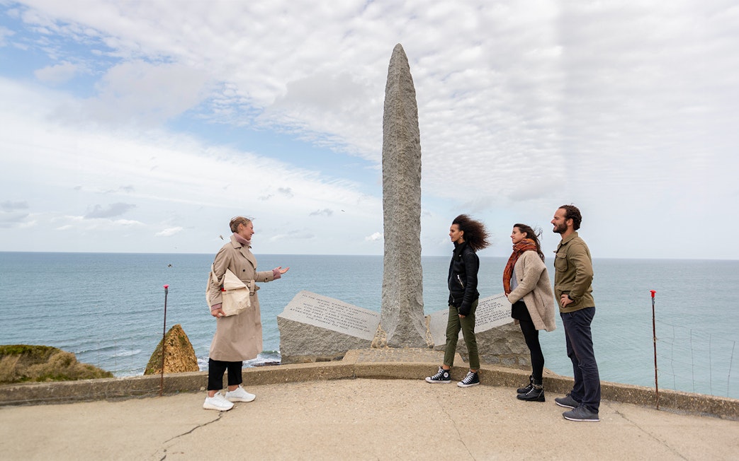Tourists with guide at Pointe Du Hoc Ranger memorial, Omaha Beach, Normandy.