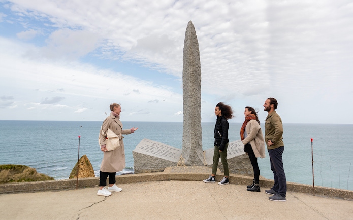 Tourists with guide at Pointe Du Hoc Ranger memorial, Omaha Beach, Normandy.