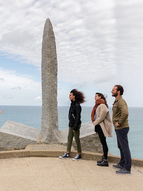 Tourists with guide at Pointe Du Hoc Ranger memorial, Omaha Beach, Normandy.
