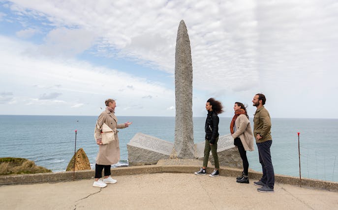 Tourists with guide at Pointe Du Hoc Ranger memorial, Omaha Beach, Normandy.