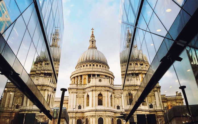 St. Paul's Cathedral reflected in modern glass buildings, London sightseeing on the Afternoon Tea Bus.