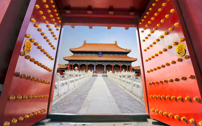 Grand red gates framing the Palace Museum entrance in the Forbidden City, Beijing, China.